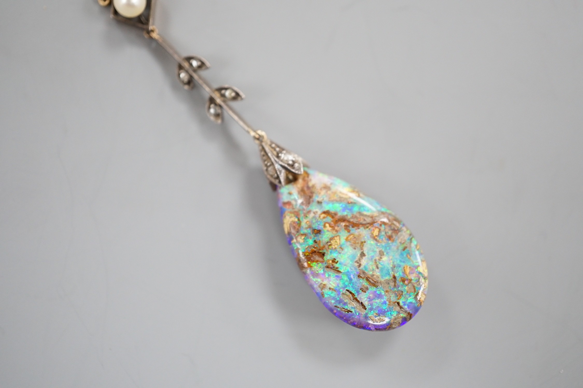 An early 20th century yellow and white metal, pear shaped black opal, rose cut diamond and seed pearl set drop pendant necklace, pendant overall 57mm, chain stamped 9ct, 37cm, gross weight 5.9 grams.